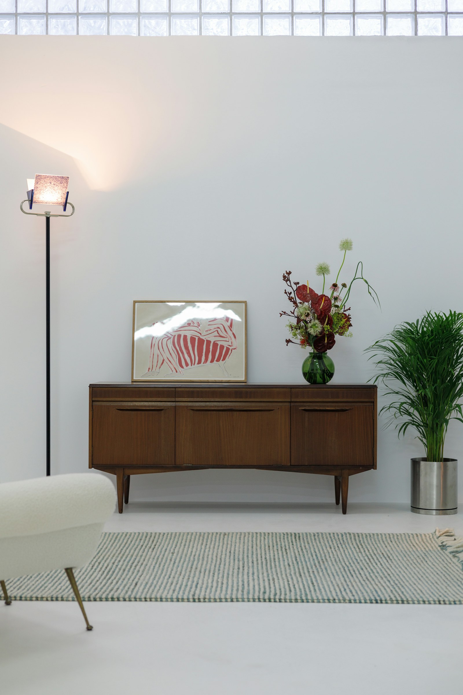Fresh, bright interior with a clean upholstered chair and area rug